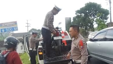 BANTU PEMUDIK, POLISI ANGKUT MOTOR MOGOK DI JALAN RAYA PROBOLINGGO 1000199427